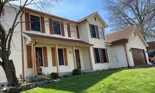 Colonial home with brown gutters matching the shutters