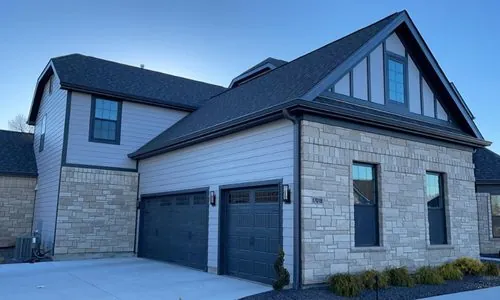 Two-story home with dark seamless gutters and downspouts